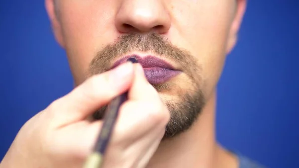 Primer plano. un barbudo se pinta los labios . — Foto de Stock