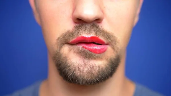 Close-up. A bearded man with painted lips bites them sexually. — Stock Photo, Image