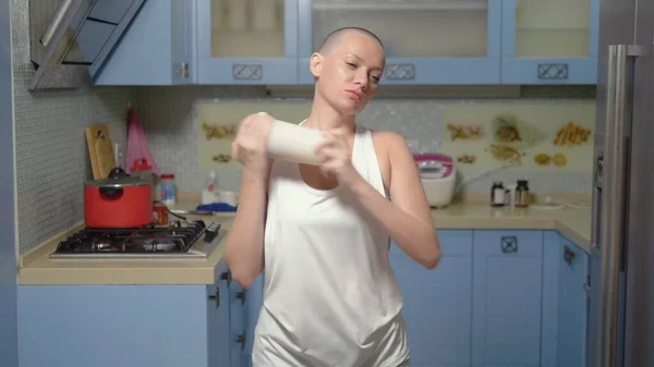 Die glatzköpfige Frau bereitet zu Hause in der Küche Sportnahrung zu. schüttelt einen Cocktail im Shaker — Stockfoto