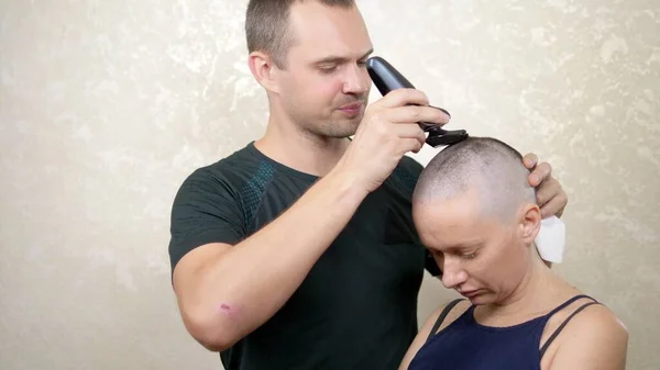 Hombre afeita la cabeza de una mujer calva. espacio de copia. aventuras de gente extraña — Foto de Stock
