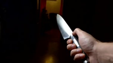 Cadılar Bayramı konsepti, şiddet. Birinci şahıs görüşü. Bıçaklı bir erkek eli karanlık bir koridor boyunca ilerliyor.