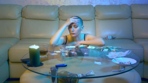 Piękna seksowna łysa kobieta odurzona pije alkohol w salonie na kanapie. Koncepcja życia nocnego i nielegalnego zażywania narkotyków. — Wideo stockowe