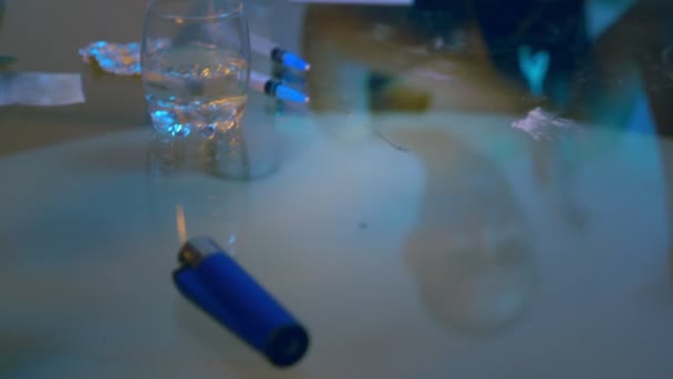 De kale verslaafde vrouw trok haar hand in een tourniquet en tikt tegen haar arm, bereidt zich voor op een injectie met drugs. reflectie in een glazen tafel — Stockvideo