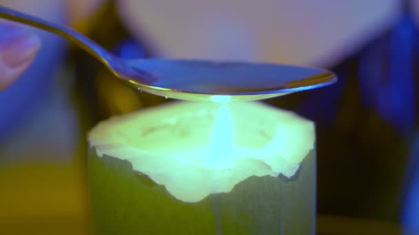 Someone is preparing a drug in a spoon over a candle flame, close-up — Stock Video