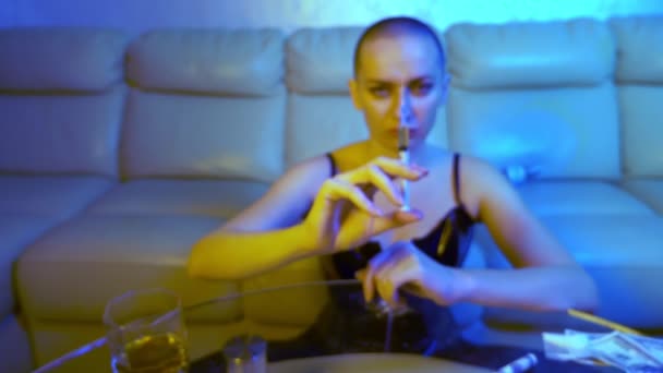 Лысая наркоманка-дилер предлагает шприц с наркотиком, протягивая руку к камере. лицо размыто, шприц в фокусе — стоковое видео