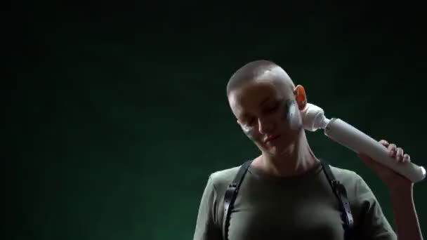 Bald woman with camouflage makeup massages her neck with a white massager — Stock Video