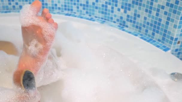 Gros plan, vue de dessus. pied mâle sur le fond de mousse dans la salle de bain. Enlèvement manuel des grains des jambes avec pierre ponce — Video