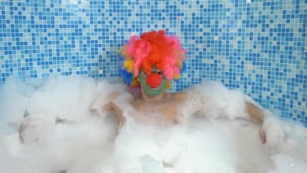 Niedlichen Clown Mann in der Badewanne mit reichlich Schaum. Humorvolles Konzept. — Stockvideo