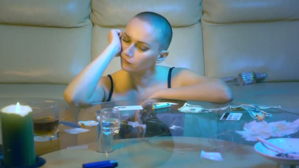 Vacker sexig skallig kvinna berusad dricker alkohol i vardagsrummet på soffan. Begreppet nattliv och olaglig narkotikaanvändning. — Stockvideo