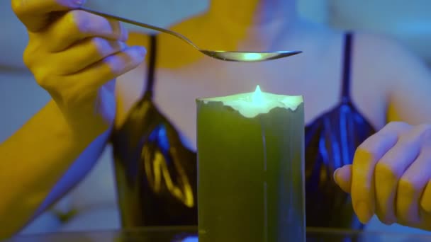 Qualcuno sta preparando un farmaco in un cucchiaio su una fiamma di candela, primo piano — Video Stock