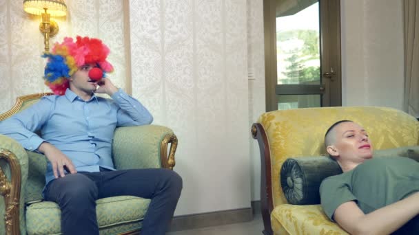 Clown psychotherapeut ontvangt een kale vrouw cliënt. Humorvol concept, parodie. Avonturen van vreemde mensen — Stockvideo