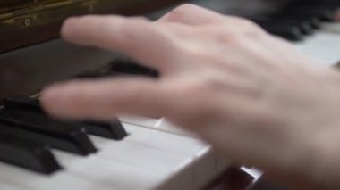 Yakın plan. Kadın elleri usta bir şekilde piyanoda arpeggio çalar.