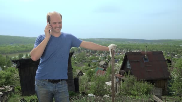 Jóképű férfi használ egy okostelefon a kertben a hegyen — Stock videók