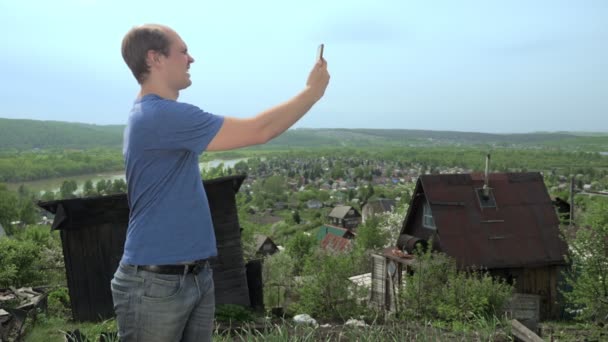 Pohledný muž používá chytrý telefon v zahradě na hoře — Stock video