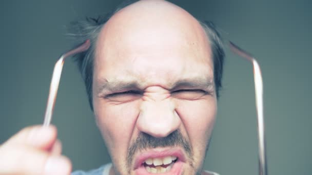 Närbild. skallig mustasch man i glasögon tittar på och ler — Stockvideo