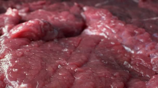 Bardzo blisko. szczegóły dotyczące surowego steku wołowego. tło żywności — Wideo stockowe