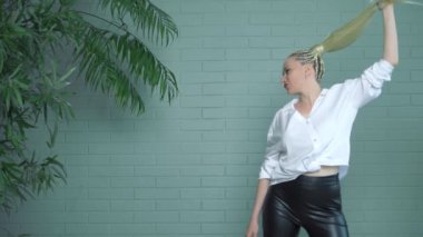 Afro örgülü ve uzun at kuyruklu zarif sarışın kadın.