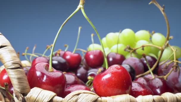 Super gros plan. Détails de cerises, raisins verts et rouges dans un panier — Video