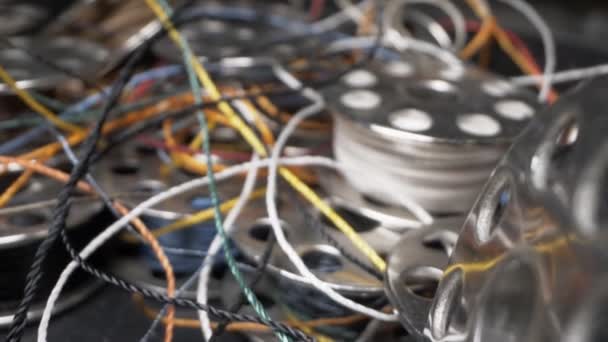 En uppsättning flerfärgade bobiner och trådar för en symaskin. supernärbild — Stockvideo