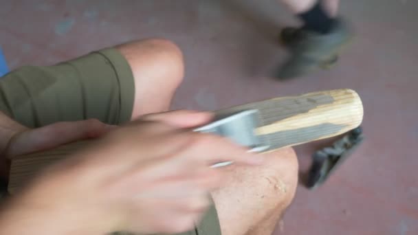 Hombre planea una cepilladora barra de madera sentado en el interior. primer plano — Vídeo de stock