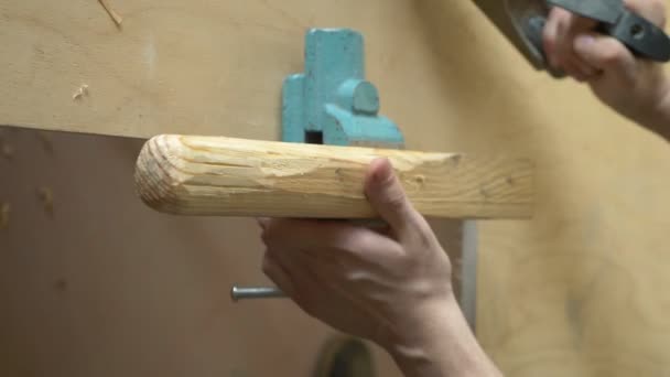 Hombre planea una cepilladora barra de madera sentado en el interior. primer plano — Vídeos de Stock