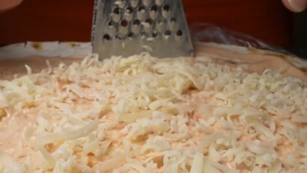 Súper cerca. queso rallado en un rallador de hierro. proceso de cocción — Vídeos de Stock