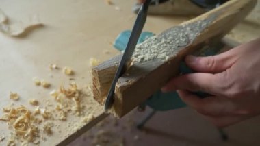 Yakın plan. Erkek eli ahşap bir kirişle kesmiş. Kapalı