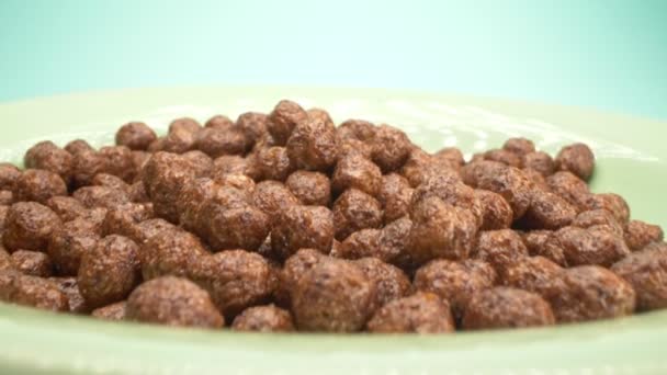 Super close up. milk is poured into breakfast cereals chocolate corn balls — Stock Video