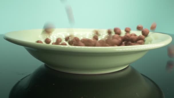 Snídaňové cereálie ve formě čokoládových kukuřičných kuliček posypané na talíři — Stock video