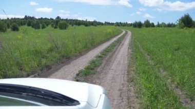 Bir tarlada kırsal bir yol manzarası, bir arabanın yan penceresinden manzara