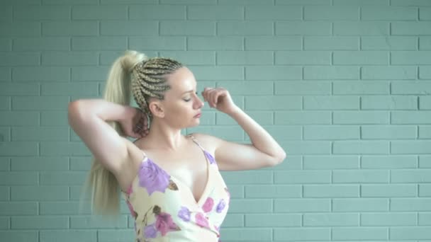 Studio shot. woman with afro braids and a long ponytail against a brick wall — Stock Video