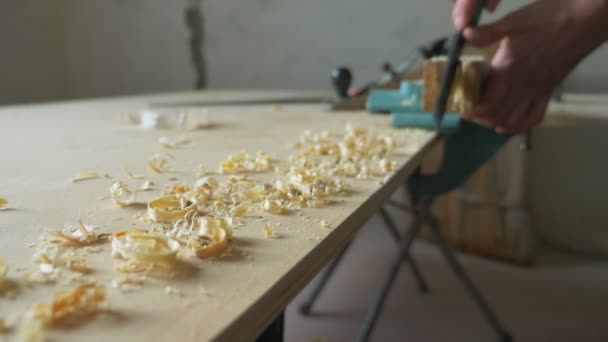 Primer plano. las manos masculinas sierra con una escofina una viga de madera. en interiores — Vídeos de Stock