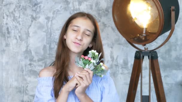 Retrato. menina adolescente bonito com um buquê de flores olhando para a câmera — Vídeo de Stock