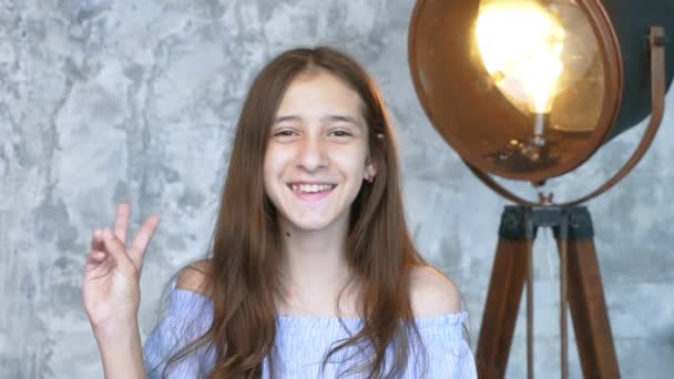Roztomilý dospívající dívka ukazující dva prsty gesto ve studiu — Stock video