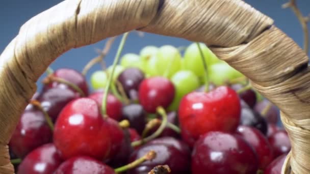 Super de perto. Detalhes de cerejas, uvas verdes e vermelhas em uma cesta — Vídeo de Stock