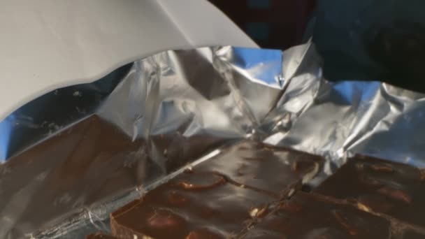 Fecha. detalhes de chocolate escuro com nozes na folha de prata — Vídeo de Stock