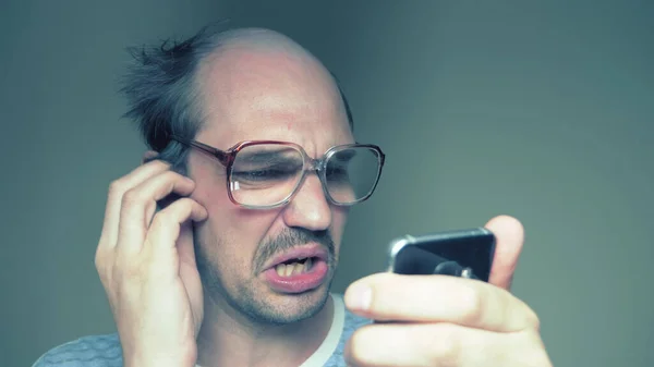 Homme chauve avec des lunettes utilise à peine un smartphone. Humour — Photo