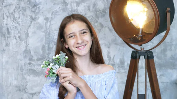 Potret. gadis muda yang lucu dengan karangan bunga melihat ke kamera — Stok Foto