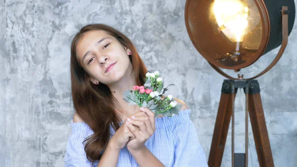 Retrato. menina adolescente bonito com um buquê de flores olhando para a câmera — Fotografia de Stock