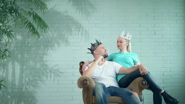 Fashionable modern pasangan pria dan wanita di mahkota duduk di atas takhta — Stok Foto