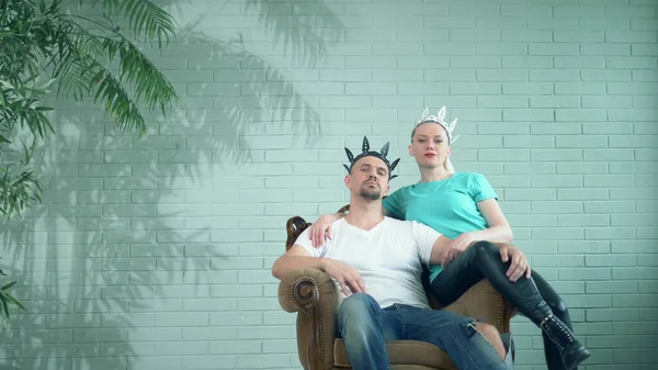 Moda pareja moderna hombre y mujer en coronas sentados en el trono —  Fotos de Stock