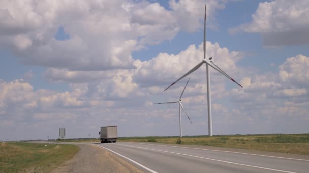 Moderna väderkvarnar längs vägen mot den blå himlen — Stockvideo