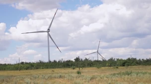 Moderní větrné mlýny podél silnice proti modré obloze — Stock video