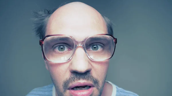 Porträt. Bösartiger glatzköpfiger Mann mit Brille schimpft in die Kamera — Stockfoto
