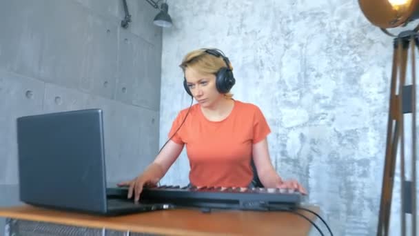 女人们在工作室里用笔记本电脑和Midi键盘制作电子音乐 — 图库视频影像