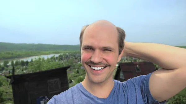 Porträtt, skallig ung man på landet tittar på kameran, ler — Stockfoto