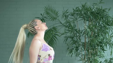 Stüdyo. Tuğla örgü ören ve uzun at kuyruklu kadın.