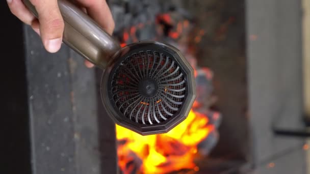 Κατακόρυφα. Κάποιος ανάβει φωτιά στη σχάρα με στεγνωτήρα μαλλιών. θολό φόντο — Αρχείο Βίντεο
