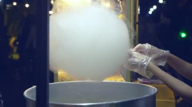 Yakın plan. Akşamları dışarıda pamuk helva yapıyorum. Koruyucu eldiven verin.