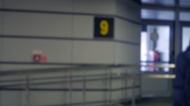 Arka plan bulanık. Havaalanı terminalinde tıbbi maske takan insanlar.